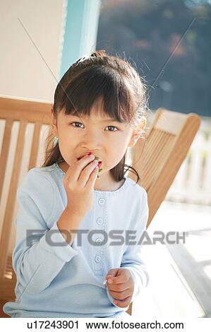A Young Girl eating a strawberry View Large Photo Image Stock Image - A Young Girl eating a strawberry. Fotosearch