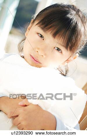 Stock Image - A Young Girl holding a towel. Fotosearch