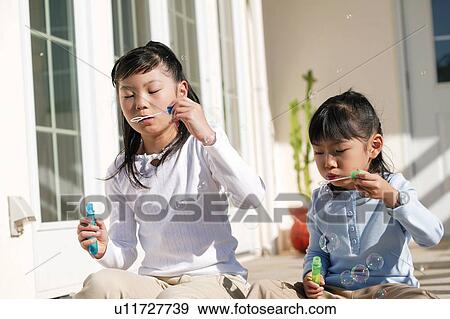 Young Girls blowing soap bubbles View Large Photo Image Stock Photo - Young Girls blowing soap bubbles. Fotosearch