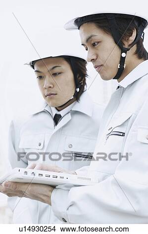 Picture - Construction Workers, Laptop Computer. Fotosearch