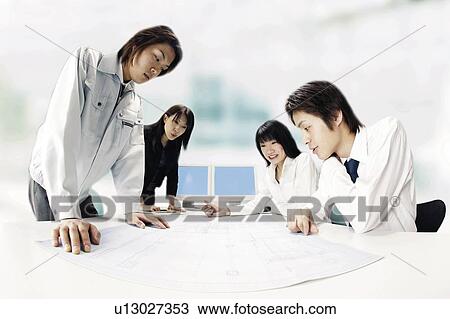Stock Image - Team Looking At Blueprint. Fotosearch