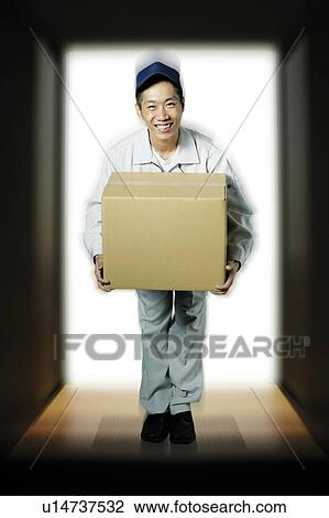 Stock Image - Young Delivery Man Carrying Package. Fotosearch