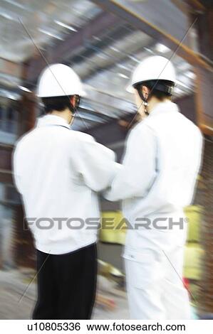 Stock Photograph - Young Workers Talking, Rear View. Fotosearch