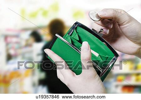 Stock Photograph - Young Woman Holding Wallet And Coin. Fotosearch