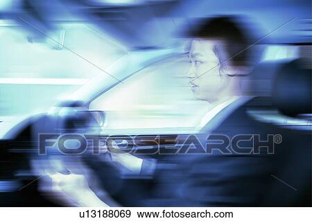 Stock Photo - A Business Man driving a car. Fotosearch