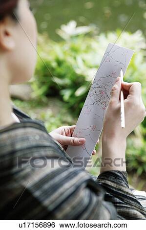 Stock Photograph - Woman composing a poem, haiku, tanka. Fotosearch