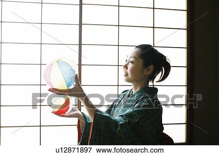 Woman playing a paper balloon View Large Photo Image Stock Photo - Woman playing a paper balloon. Fotosearch