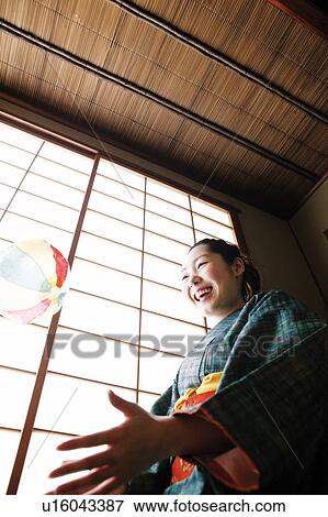 Woman playing a paper balloon View Large Photo Image Stock Photo - Woman playing a paper balloon. Fotosearch