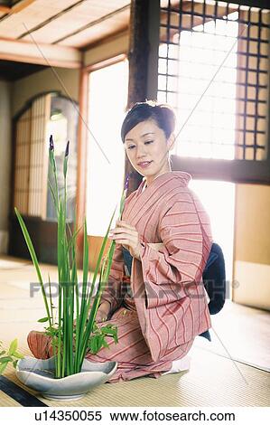 Stock Photography - Woman putting on a kimono, kado. Fotosearch