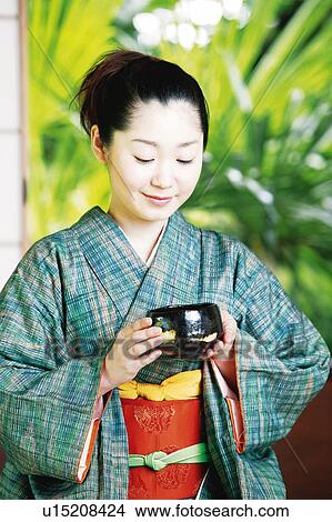 Picture - Woman putting on a kimono. Fotosearch