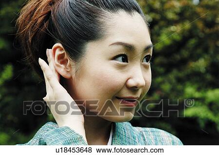 Stock Photo - Woman putting on a kimono. Fotosearch