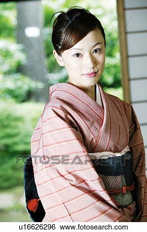 Woman putting on a kimono View Large Photo Image Stock Photograph - Woman putting on a kimono. Fotosearch