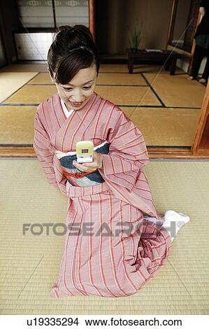 Picture - Woman using a portable phone. Fotosearch