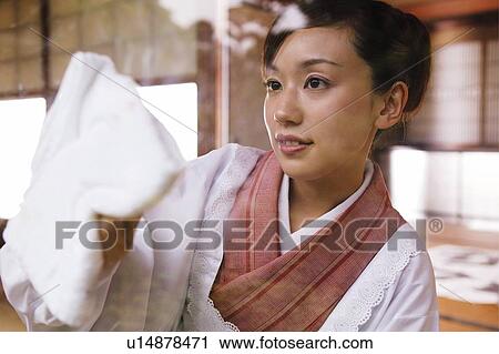 Stock Image - Woman wiping a window. Fotosearch