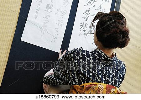 Stock Photo - Woman writing charactersin a Japanese paper. Fotosearch