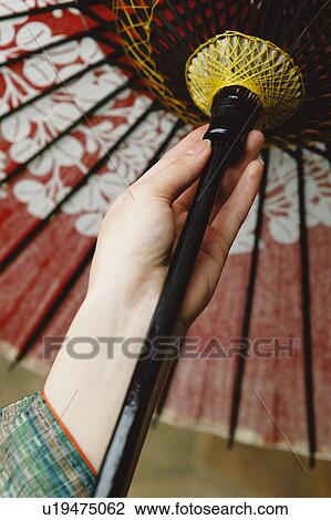 Stock Image - Woman's hand putting up a Japanese umbrella. Fotosearch