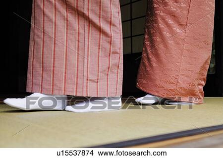 Picture - Women putting on a kimono, close up. Fotosearch