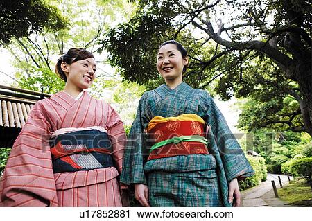 Stock Image - Women putting on a kimono. Fotosearch