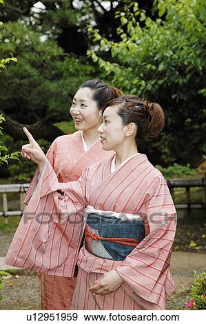 Stock Photo - Women putting on a kimono. Fotosearch