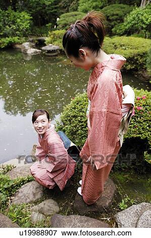 Women putting on a kimono View Large Photo Image Stock Photo - Women putting on a kimono. Fotosearch