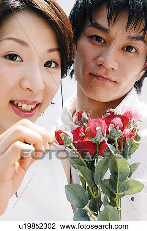 Stock Image - Couple and bunch of flowers. Fotosearch