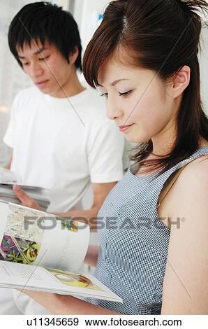 Couple reading magazines in the room, Close-up View Large Photo Image Stock Photo - Couple reading magazines in the room, Close-up. Fotosearch