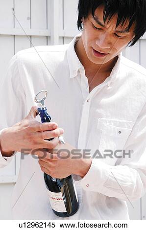 Stock Photography - Man opening a wine. Fotosearch