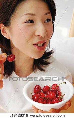 Woman eating a cherry View Large Photo Image Stock Photo - Woman eating a cherry. Fotosearch