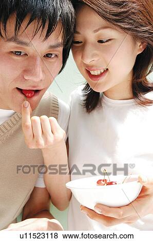 Woman feeding a cherry to a man View Large Photo Image Stock Photo - Woman feeding a cherry to a man. Fotosearch