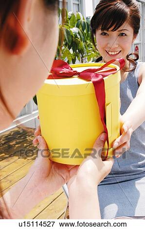 Stock Photo - Woman giving a present to friend. Fotosearch