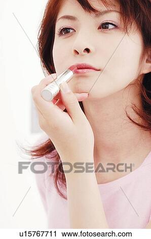 Stock Image - Woman making up her face. Fotosearch