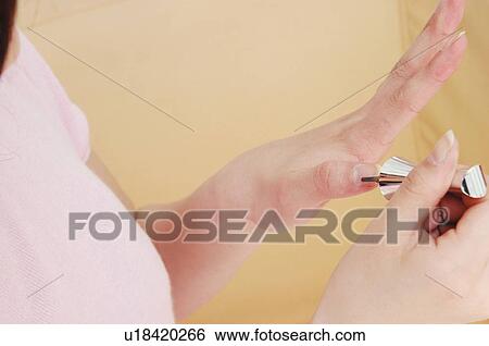 Stock Photograph - Woman manicuring her nails, Close-up. Fotosearch