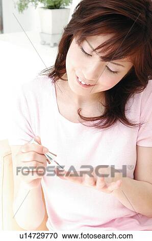 Stock Image - Woman manicuring her nails. Fotosearch
