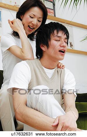 Stock Image - Woman massaging man's shoulder. Fotosearch