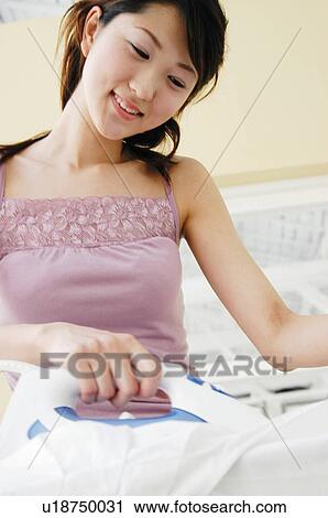 Stock Image - Woman pressing clothes. Fotosearch