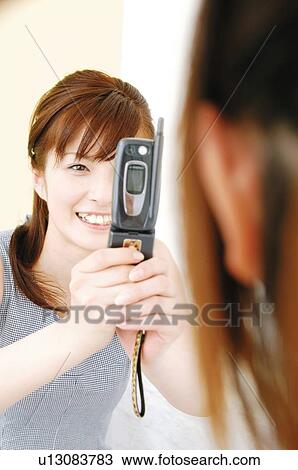 Woman taking a picture with a portable phone View Large Photo Image Stock Image - Woman taking a picture with a portable phone. Fotosearch