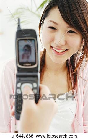 Woman taking a picture with a portable phone View Large Photo Image Stock Photo - Woman taking a picture with a portable phone. Fotosearch