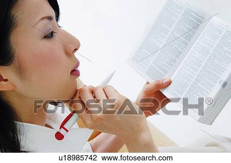 Stock Image - Woman using a dictionary. Fotosearch