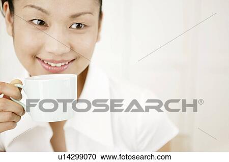 Stock Image - Young Woman Drinking Coffee. Fotosearch
