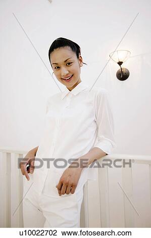 Stock Image - Young Woman Leaning On Fence. Fotosearch