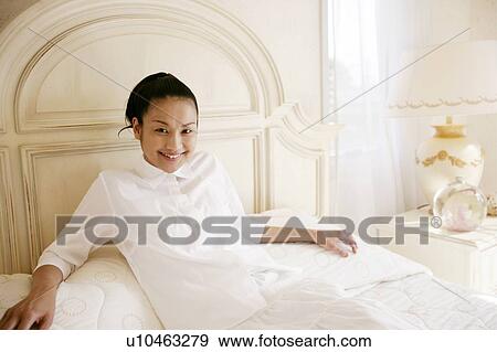 Stock Photo - Young Woman Lying Down On Bed. Fotosearch