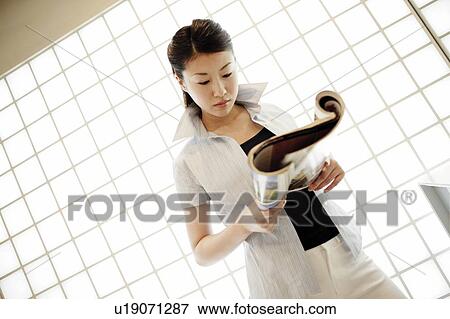 Stock Photo - Young Woman Reading Magazine. Fotosearch