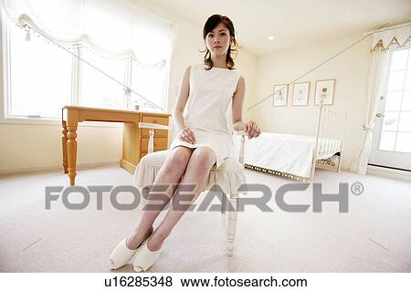 Stock Photo - Young Woman Sitting On Chair. Fotosearch