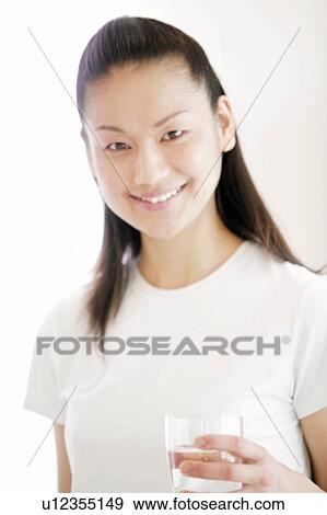Stock Photo - Young Woman Smiling and Holding Glass. Fotosearch