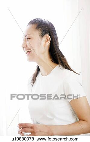 Stock Photo - Young Woman Smiling and Holding Glass. Fotosearch