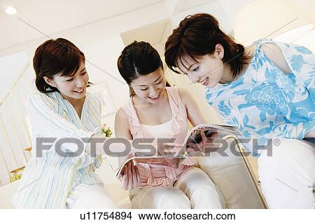 Picture - Young Women Reading Magazine. Fotosearch