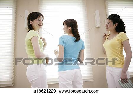 Stock Photo - Young Women Standing and Talking. Fotosearch