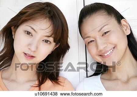 Stock Photo - Young Women Standing Side By Side. Fotosearch
