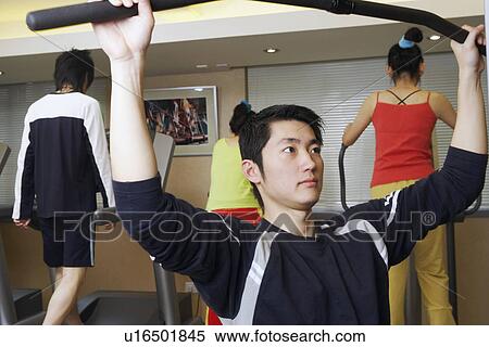 Stock Photography - Four people exercising in a gym. Fotosearch