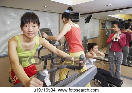 Picture - Four young women exercising in a gym. Fotosearch